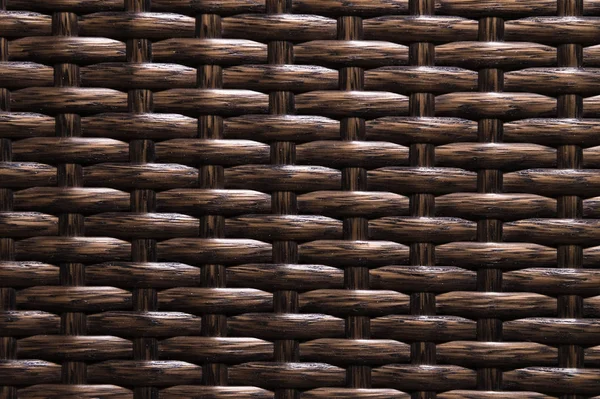 Close-up Fondo marrón oscuro es un elemento de muebles de mimbre hechos de fibras de polímero. Sustrato de lujo sintético — Foto de Stock
