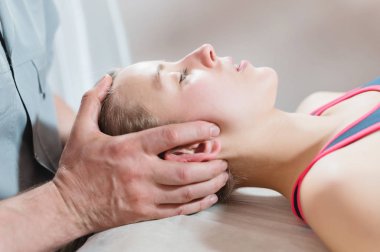 İçgüdüsel doktor genç bir kızın kafatasının elle düzenlenmesiyle meşgul. Alternatif tıp. Sağlığı Önleme Kavramı