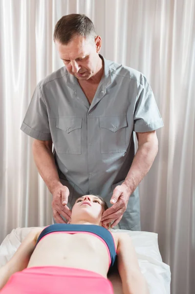 The visceral doctor is engaged in manual editing of the skull of a young girl. Alternative medicine. Health Prevention Concept — Stock Photo, Image