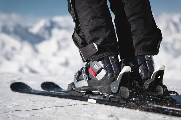 Το κοντινό βήμα των αθλητών με πόδι σε μπότες του σκι ανεβαίνει στα σκι με φόντο τα χιονισμένα βουνά του Καυκάσου σε μια ηλιόλουστη μέρα. Χειμερινή αθλητική ιδέα — Φωτογραφία Αρχείου