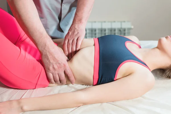 Manlig manual visceral terapeut massör behandlar en ung kvinnlig patient. Redigera de inre organen och eliminering av adhesioner i magen — Stockfoto