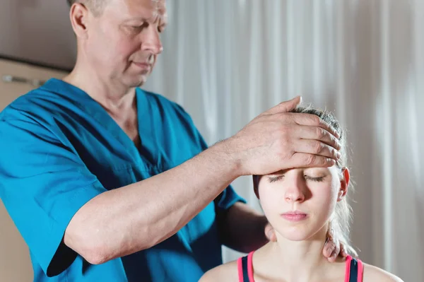 The visceral doctor is engaged in manual editing of the skull of a young girl. Alternative medicine. Health Prevention Concept — Stock Photo, Image