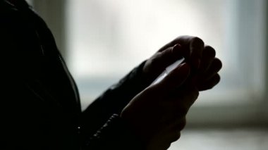 Kadın ellerinin siluetinin yakın çekimbir paket sigara açılması ve oradan bir sigara almak. Düşük anahtar sigaranın zarar acımasız kavramı