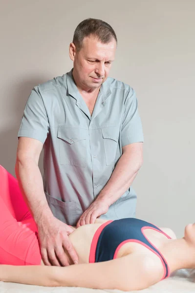 Male manual visceral therapist masseur treats a young female patient. Edit the internal organs and the elimination of adhesions in the stomach — Stock Photo, Image