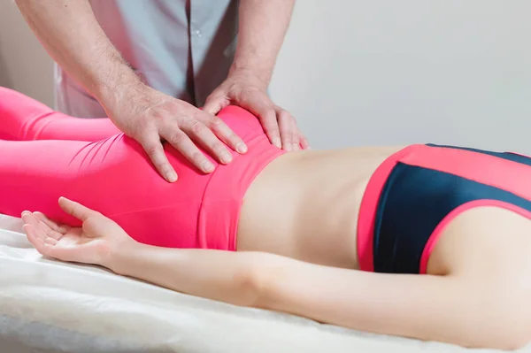 Närbild av en ung flickor ryggrad bas redigering av en manlig sjukgymnast av visceral massage. Händerna på läkaren set och knåda svanskotan av patienten — Stockfoto