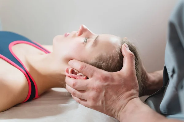 The visceral doctor is engaged in manual editing of the skull of a young girl. Alternative medicine. Health Prevention Concept — Stock Photo, Image