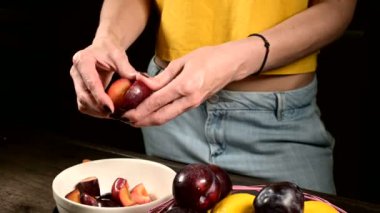 Bir ev mutfağında kadın elleri yakın çekim bir erik bıçağı ile taze çilek kesme ve limon bir sepet yanında onlardan bir kemik alarak. Sağlıklı gıda ve vitamin kavramı