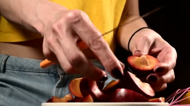 家庭厨房里女性双手的特写镜头用梅刀切出新鲜的浆果,并在一篮子柠檬旁边取下一块骨头。健康食品和维生素的概念 — 图库视频影像