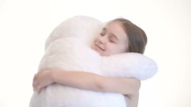 Stüdyoda beyaz bir arka plan üzerinde büyük bir oyuncak ayı ile sarılma pigtails ile sevimli bir beyaz kız Portresi
