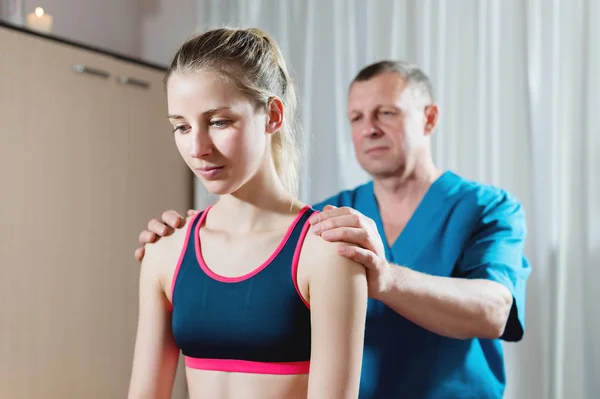 Masajista manual visceral masculino trata a una paciente joven. Diagnóstico de hombros y antebrazos — Foto de Stock