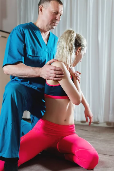 男性の手動内臓セラピストマッサージ師は若い女性患者を扱う。脊椎と肋間系のストレッチ — ストック写真