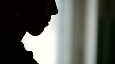 Bir kadının siluetinin yakın çekim dudaklarına bir sigara yapıştırarak ve bir çakmak ve duman soluma onu tutuşturma yüz. Düşük anahtar sigaranın zarar acımasız kavramı