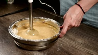 Bir blender sünger kek için hamur yenerek bir metal kase mutfakta bir pasta kız yakın çekim. Ev yemekleri şekerlemeleri