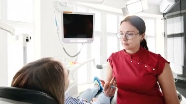 Gözlüklü bir diş hekimi kadın ile istişare genç bir kız bir stamotoloji ofisinde bir sandalyede oturuyor. Doktor ve hastanın konuşma