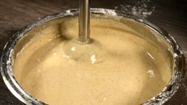 Bir blender sünger kek için hamur yenerek bir metal kase mutfakta bir pasta kız yakın çekim. Ev yemekleri şekerlemeleri