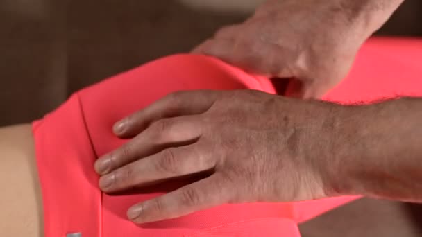 Nahaufnahme einer jungen Mädchen Wirbelsäule Schnitt durch einen männlichen Physiotherapeuten der viszeralen Massage. die Hände des Arztes legen und das Steißbein des Patienten kneten — Stockvideo
