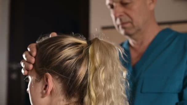 Der viszerale Arzt ist mit der manuellen Bearbeitung des Schädels eines jungen Mädchens beschäftigt. Alternativmedizin. Gesundheitspräventionskonzept — Stockvideo