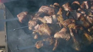 Yakın çekim lezzetli et dilimleri şiş üzerinde güneşli bir gün ızgara açık havada kızarmış. Sulu kebap et çanak