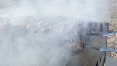 Yakın çekim lezzetli et dilimleri şiş üzerinde güneşli bir gün ızgara açık havada kızarmış. Sulu kebap et çanak