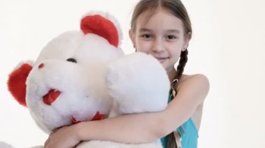 Stüdyoda beyaz bir arka plan üzerinde büyük bir oyuncak ayı ile sarılma pigtails ile sevimli bir beyaz kız Portresi