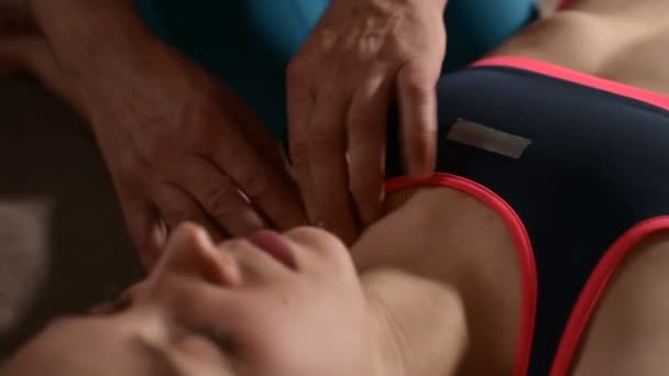 젊은 소녀 환자에게 웰빙 마사지를하고 남성 물리 치료사 손의 클로즈업. 골병증 및 비 전통적인 수동 의학. 어깨 치료 — 비디오
