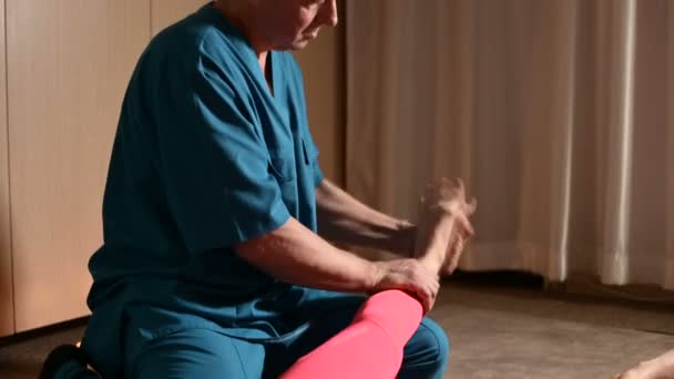 Мужчина-физиотерапевт делает оздоровительную ручную процедуру для молодой девушки-пациента. Остеопатия и нетрадиционная медицина. Массаж ног телят — стоковое видео