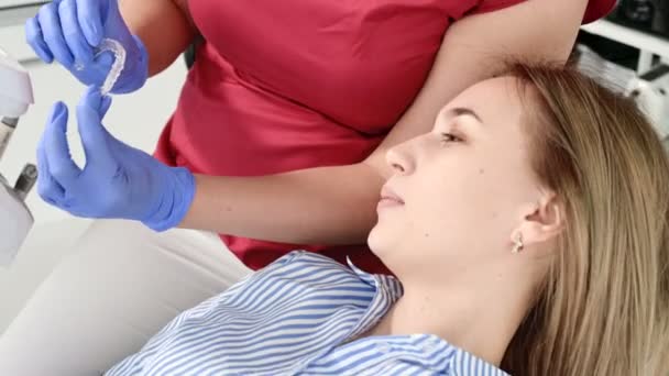 Female dentist shows and explain problem on gypsum model to young woman patient — Stock Video