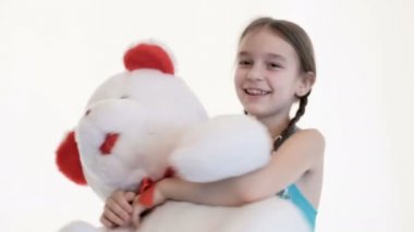 Stüdyoda beyaz bir arka plan üzerinde büyük bir oyuncak ayı ile sarılma pigtails ile sevimli bir beyaz kız Portresi