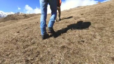İki turist gezgin fotoğrafçıların bacakları güneşli bir günde yokuş yukarı gitmek