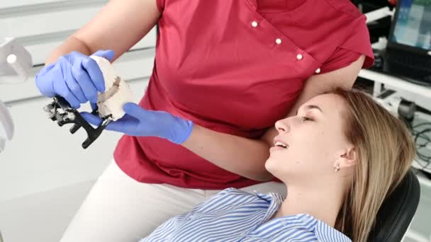 여성 치과 의사 쇼 와 젊은 여자 환자에 석고 모델에 문제를 설명 — 비디오