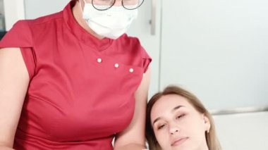 Kadın diş hekimi genç kadın hastaya alçı modeli ile ilgili sorunu gösteriyor ve açıklıyor