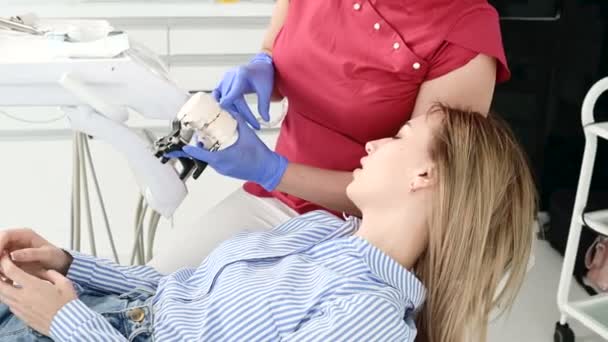 Dentista feminino mostra e explica problema no modelo de gesso para paciente jovem — Vídeo de Stock