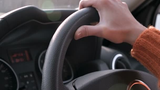 Close-up de uma mão feminina em uma camisola laranja dirigindo um carro fora da cidade. câmara lenta Mulher dirigindo um carro — Vídeo de Stock