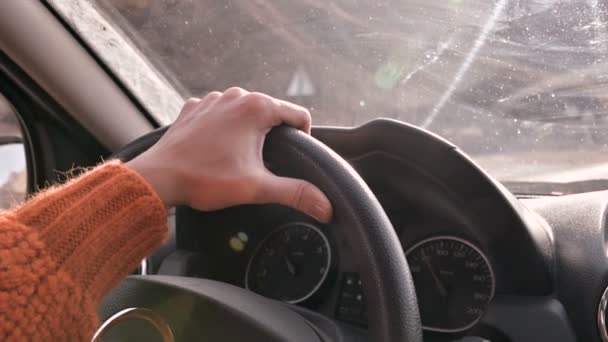オレンジ色のセーターを片手に、都会の外で車を運転している女性の手のクローズアップ。スローモーションの女性が車を運転する — ストック動画