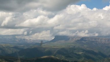 Destansı platonun eteklerinde, Kuzey Kafkasya'daki yeşil vadinin 4k timelapse'i. Hava durumu değişikliği ve telefoto tahmini