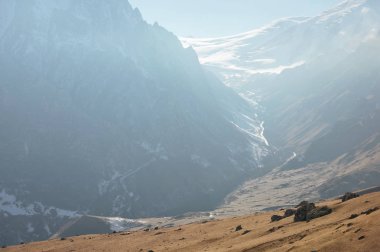 Kafkasya'da yaklaşan bulutlar ile karlı dağ yamaçları ve buzulların dağ manzarası