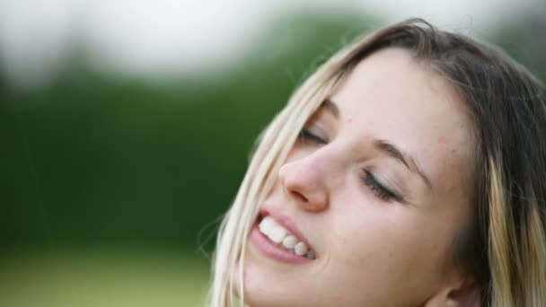 Nahaufnahme Porträt eines glücklichen attraktiven kaukasischen blonden Mädchens mit nassen Haaren während eines Regens in der Natur draußen auf einem Weizenfeld. Glückshoffnung Flirten und Koketterie — Stockvideo