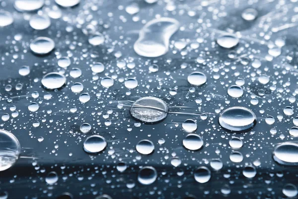 Close-up of raindrops of different sizes on the surface covered with cling film. Moisture weather and humidity concept — Stock Photo, Image
