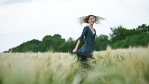 Retrato de uma loira caucasiana atraente feliz com cabelo molhado girando na chuva na natureza. Campo exterior de trigo. Felicidade esperança flertando e coquetry. Profundidade de campo rasa — Vídeo de Stock