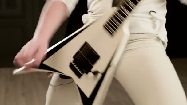 Primo piano Elegante chitarrista solista con dreadlocks in testa e vestiti bianchi su sfondo nero che suona espressivamente la chitarra bianca in uno studio nero — Video Stock