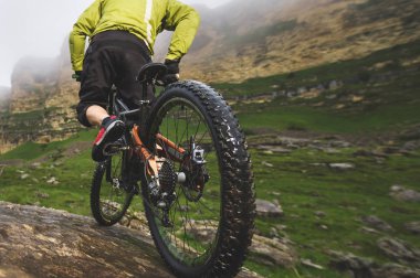 Arka görüş geniş açı kısmen bir dağ bisikleti bir adam kayalık arazi üzerinde seyahat. Bir dağ bisikleti ve mtb yokuş aşağı kavramı
