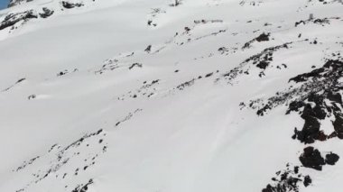 Bir kış dağ manzara havadan görünümü. Hotel Bivuak, güney Elbrus bölgesinin tatil beldesinin karla kaplı kayalık yamaçlarında yer almaktadır. Ekstrem dağ tatili