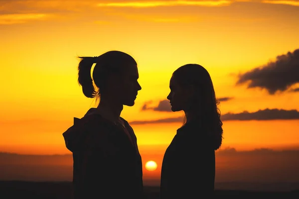 Taillensilhouetten eines jungen Jahrtausendpaares, das sich in einen Mann und ein Mädchen verliebt, schauen einander an. zwei Porträts eines jungen Paares bei Sonnenuntergang — Stockfoto