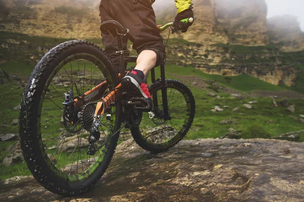 Vista posteriore grandangolare in parte un uomo in mountain bike viaggia su terreni rocciosi. Il concetto di mountain bike e mtb downhill — Foto Stock