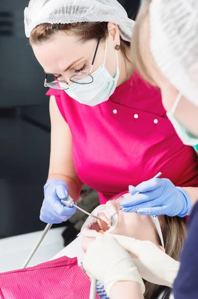 Close-up uma jovem em uma cadeira de dentista sofre um diagnóstico de rotina depois de remover aparelhos com limpeza e dimensionamento. Estamatologia na vida e na clínica — Fotografia de Stock