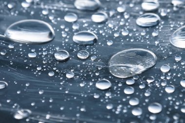 Yüzeyde farklı boyutlarda yağmur damlalarının yakın çekim film sarın kaplı. Nem havası ve nem konsepti
