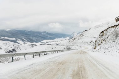 Kışın boş dağ asfalt yolu bulutlu bir günde karla kaplı. Kış buz ve seyahat bir araba sürüş kavramı