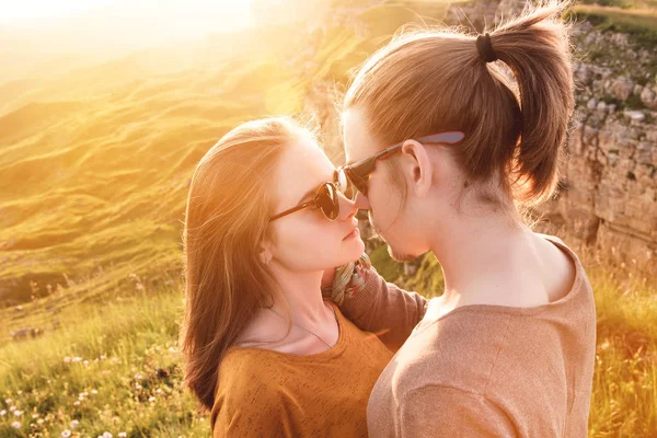 Retrato de una romántica pareja joven en la naturaleza. Un hombre y una chica con gafas de sol se miran con cariñosas miradas en la pista. El concepto de una familia joven y relaciones heterosexuales — Foto de Stock