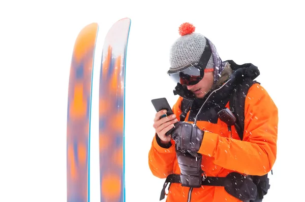 一个专业运动员滑雪者的肖像,他手中有一部手机,旁边是白色背景的滑雪板。体育与交流 — 图库照片