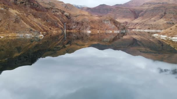 Vista aérea da paisagem de um lago de montanha rodeado por falésias épicas em um dia nublado. Costa rochosa. Água doce — Vídeo de Stock